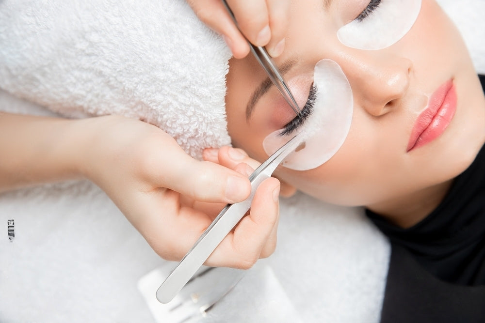 Beauty treatment in progress – lash technician working on client's eyelashes