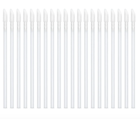A collection of white velour applicators with pointed tips, used for eyelash extensions or other cosmetic treatments.