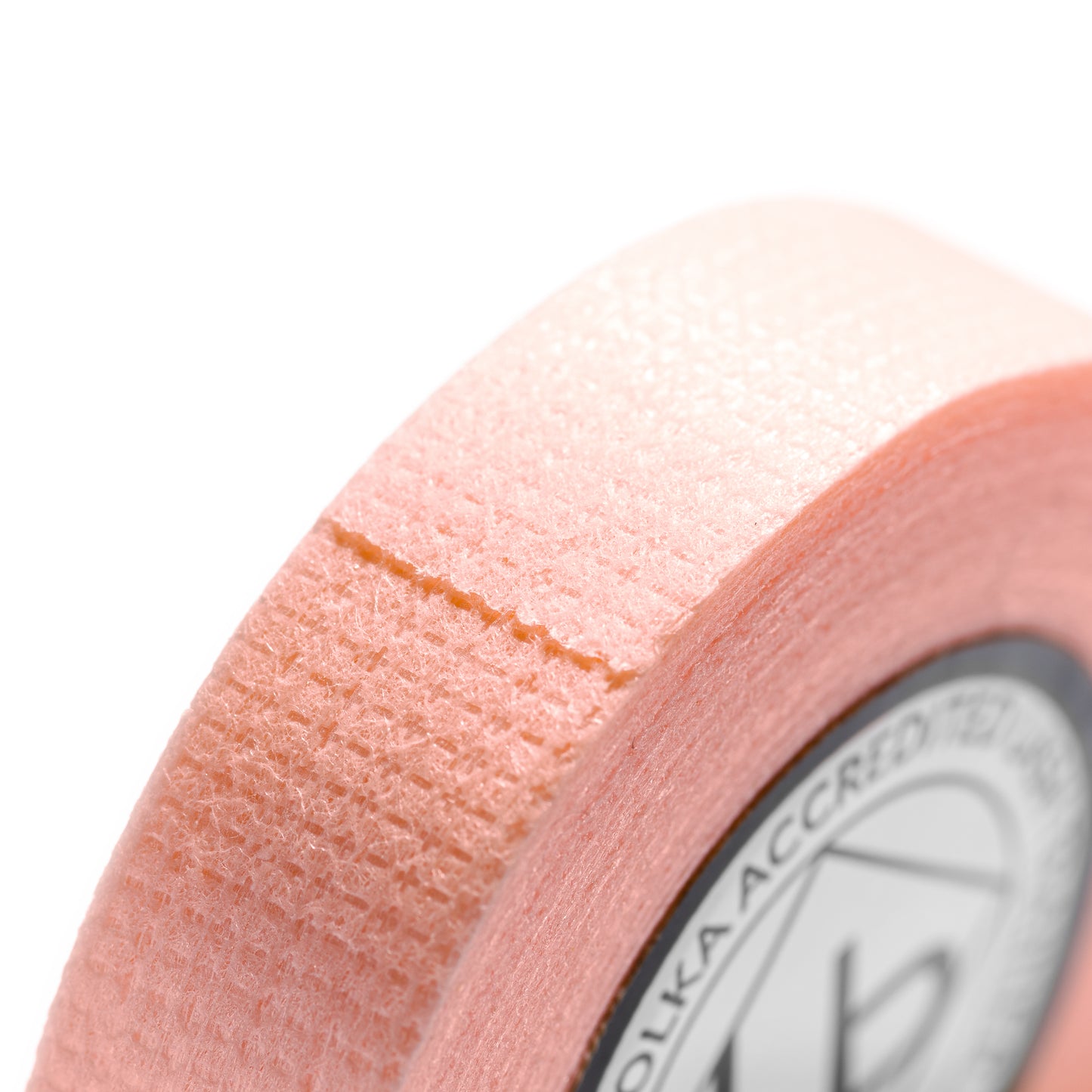 Orange perforated tape roll for lash extension and beauty procedures.