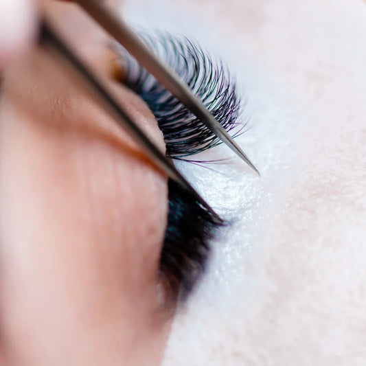 Tweezers separating eyelashes during lash lamination treatment