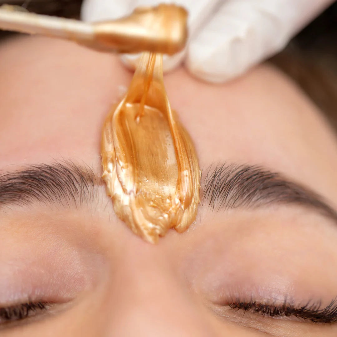 Wax applied between eyebrows during brow shaping treatment